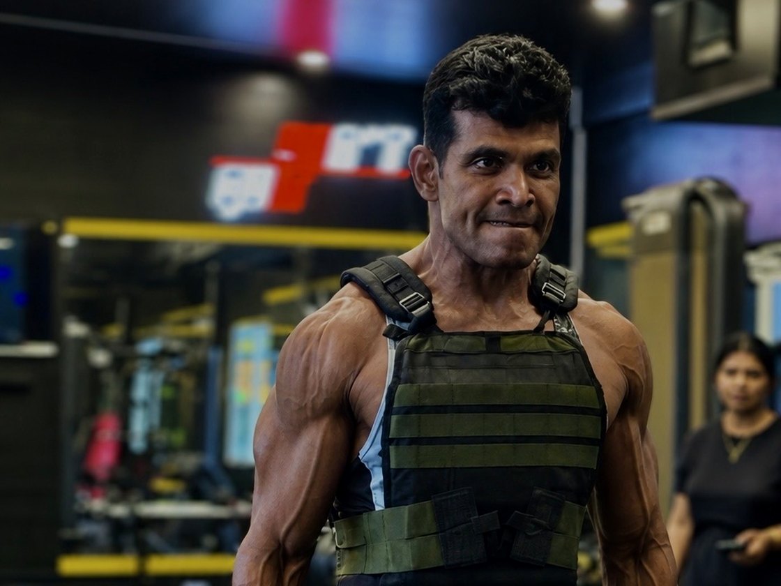 Coach Joby training with a weighted vest and dumbbells