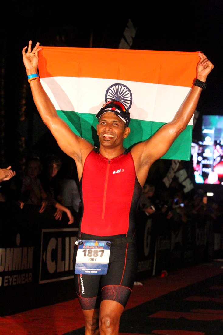 Coach Joby finishing an Ironman with the Indian flag